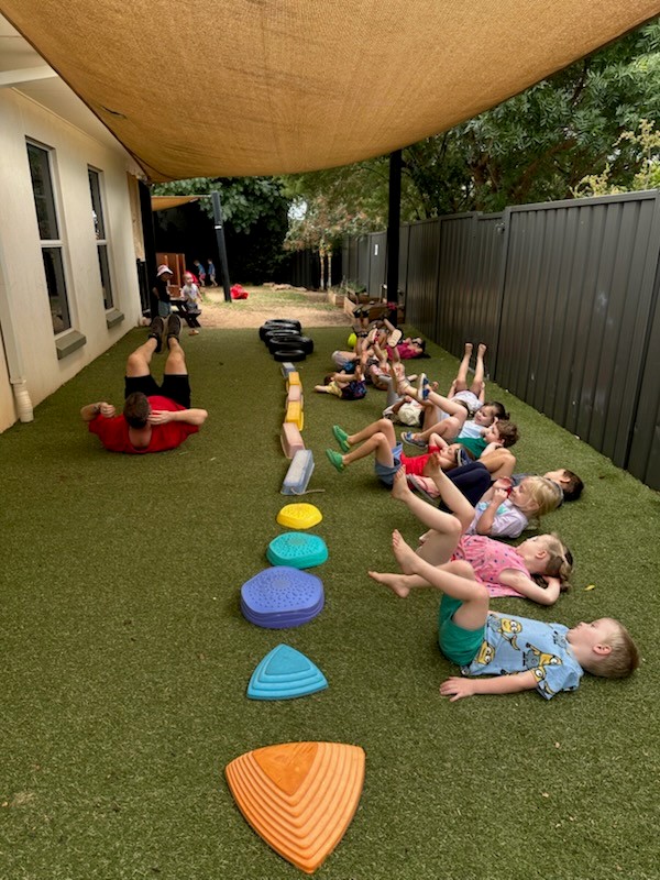 Children and an educator taking part in active outdoor play