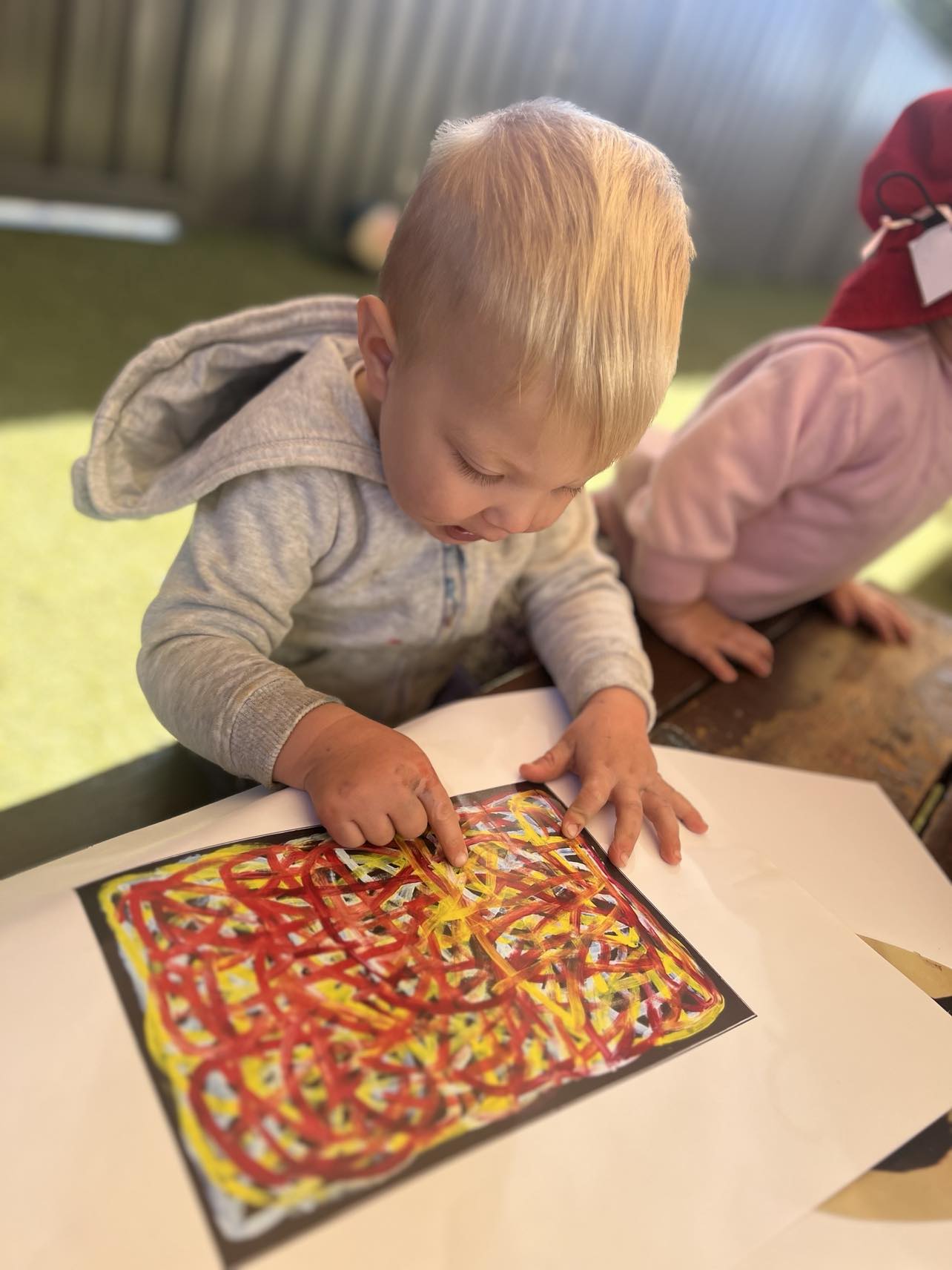 A young child exploring colour and texture through art