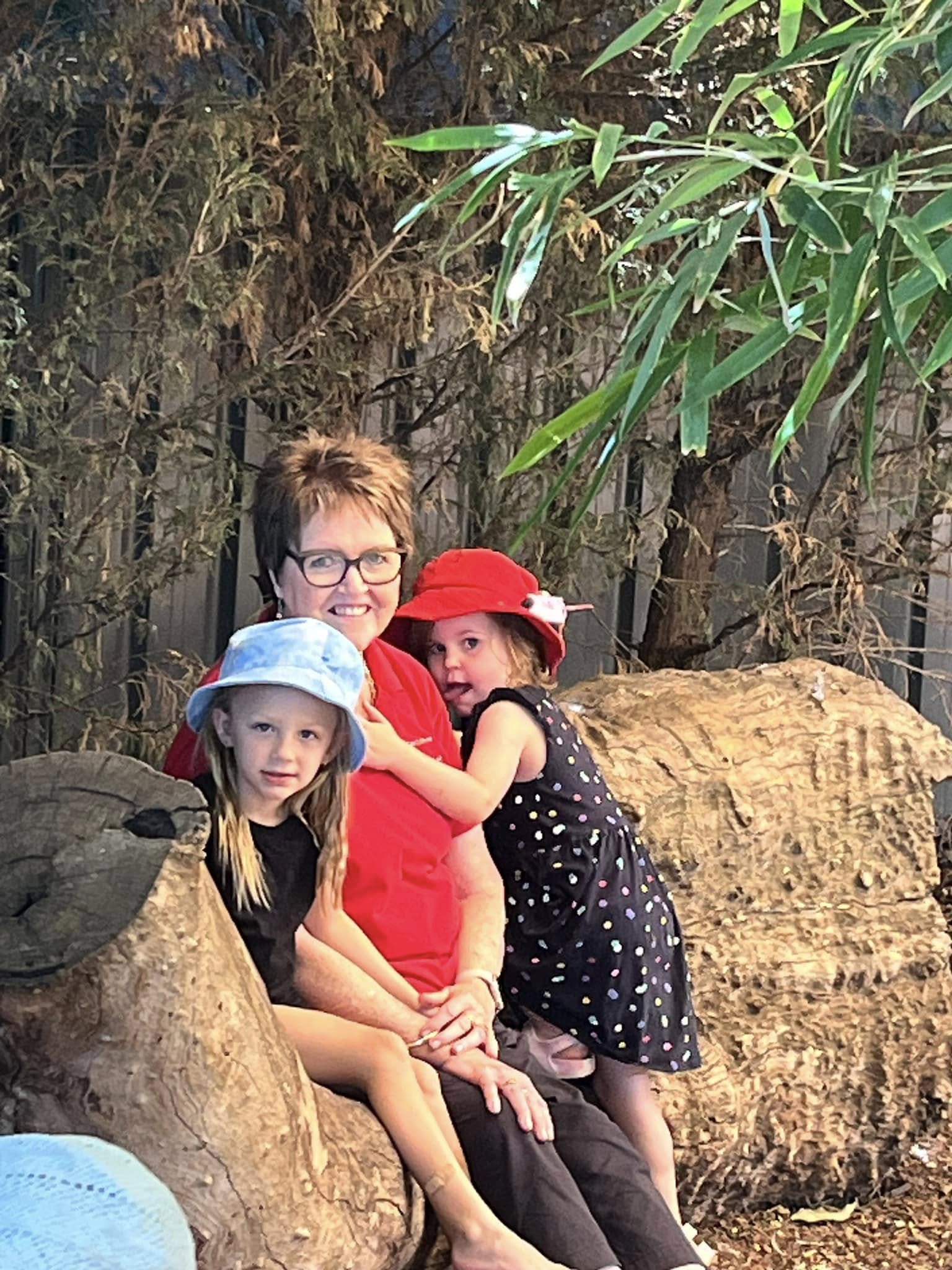 An educator and children sharing a warm moment in the outdoor environment