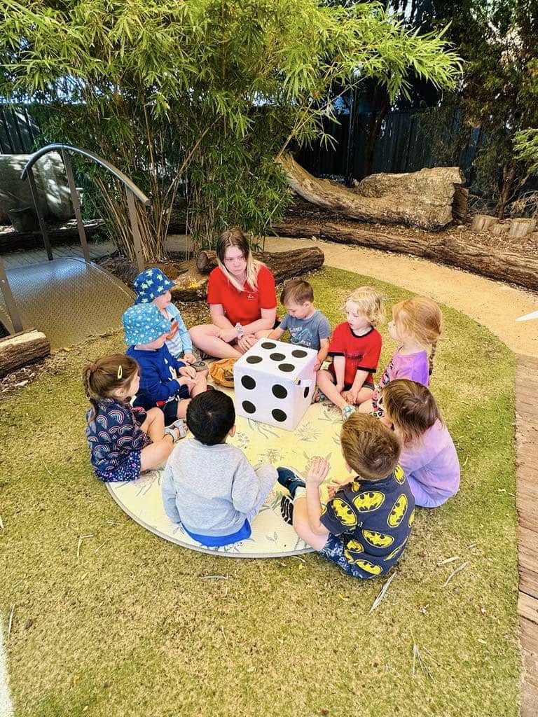 Children and an educator learning together in a small outdoor group